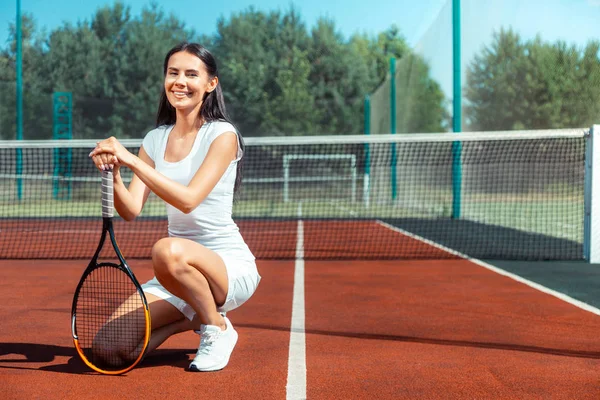 Mujer morena usando ropa deportiva sosteniendo raqueta de tenis — Foto de Stock