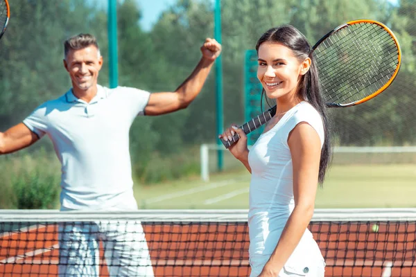 Esposa sorrindo depois de jogar tênis com marido bonito — Fotografia de Stock