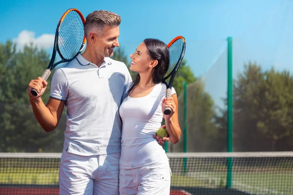 Paar hält Schläger in der Hand, während es Tennis liebt — Stockfoto