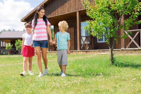 Kinderen en Mama lopen buiten privé huis samen — Stockfoto