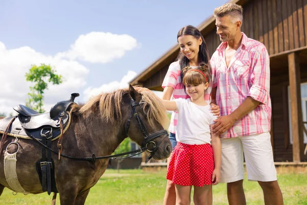 Lány érzés csodálatos rövid idő megható ló álló mellett szülők — Stock Fotó