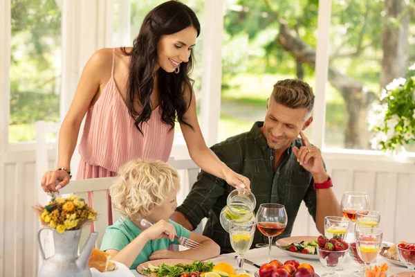 Zorgzame Mama gieten limonade voor haar mooie blonde zoon — Stockfoto