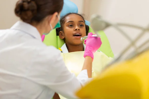 Афроамериканець дівчина сидить у стоматологів стілець — стокове фото