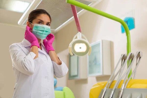 Arts die een groen masker en aseptische handschoenen draagt — Stockfoto