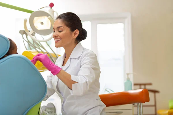 Dentista caucásica de mediana edad que realiza un examen dental — Foto de Stock