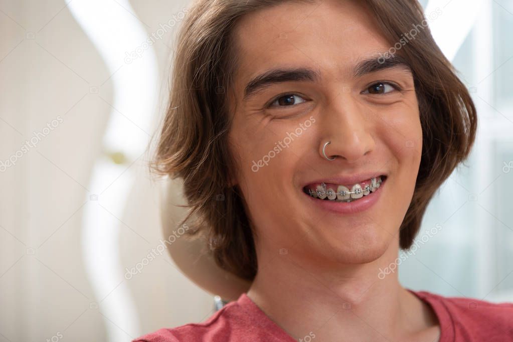 Dark-haired young Caucasian male patient with dental braces