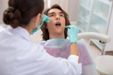 Çekici genç adam bir diş sandalyede yalan