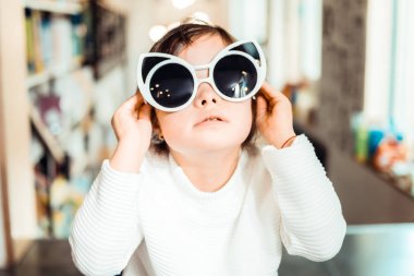 Down sendromlu küçük çocuk büyük kedi şeklinde güneş gözlüğü takıyor