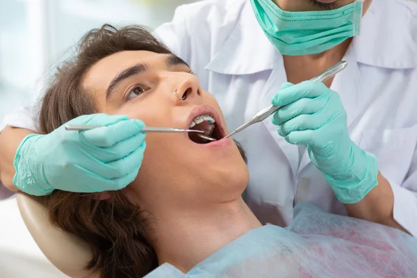 Dark-haired brown-eyed teenager lying in a dentists chair — Stock Photo, Image