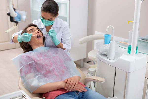 Dentista poniendo los aparatos dentales en los dientes de sus pacientes —  Fotos de Stock