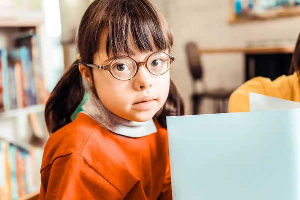 Linda niña con flequillo largo y gafas con libro abierto — Foto de Stock