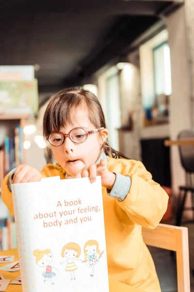 Nieuwsgierig kind met problemen met gezondheid omgaan met nieuw boek — Stockfoto