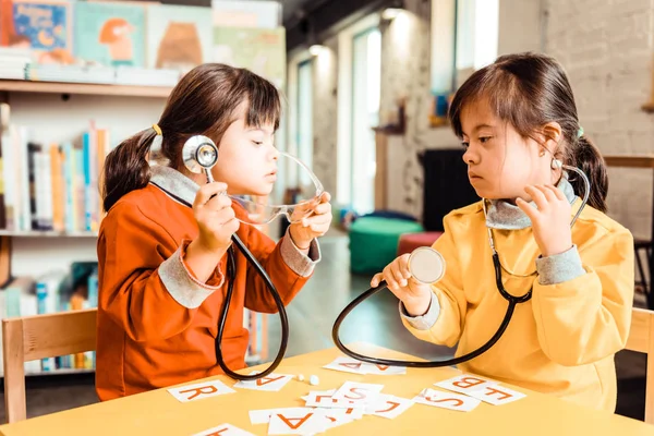 Active young girl with down syndrome playing in a role play game — Stock Photo, Image