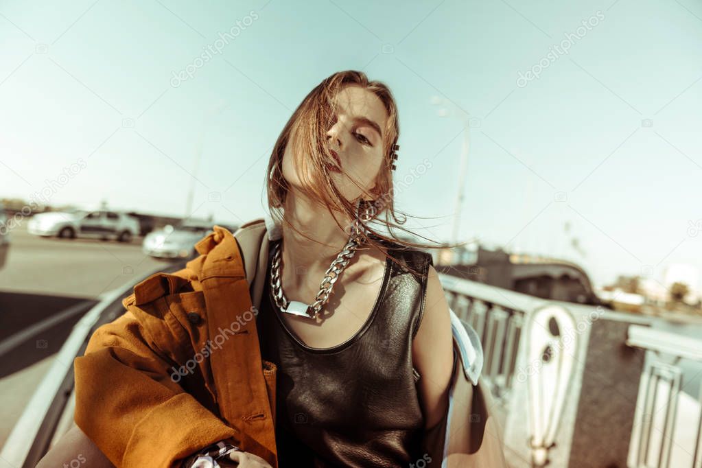 Appealing young girl wearing heavy chain and bulky earrings