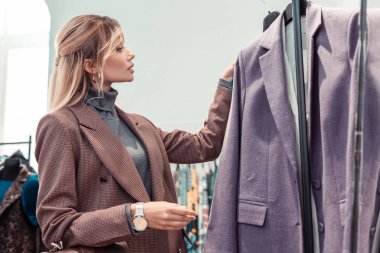 El saati giyen iş kadını yeni ceket seçerek