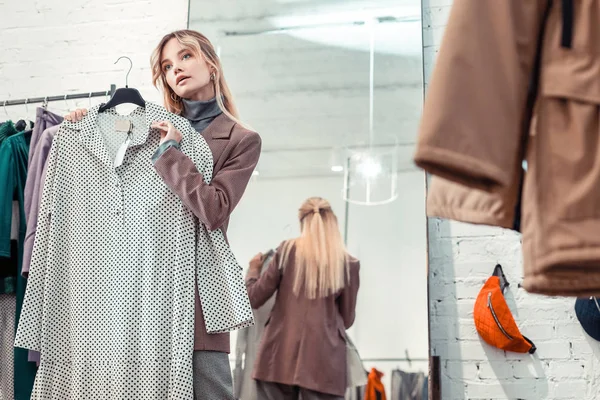 Vrouw draagt stijlvolle jas zoeken nieuwe jurk in Boutique — Stockfoto