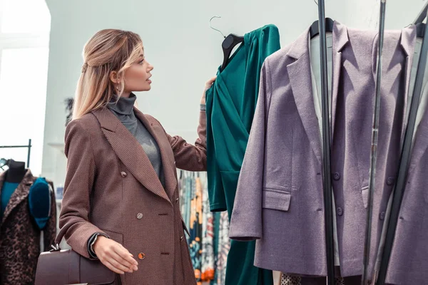 Zakenvrouw kijken naar mooie groene jurk in winkelcentrum — Stockfoto