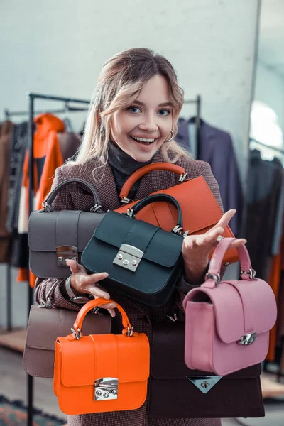 Empresaria propietaria de boutique de moda sosteniendo bolsos de mano pequeños —  Fotos de Stock