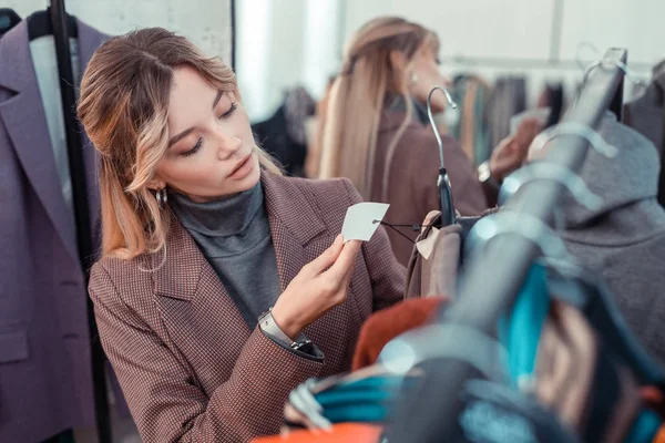 Zakenvrouw het prijskaartje controleren tijdens het winkelen na het werk — Stockfoto