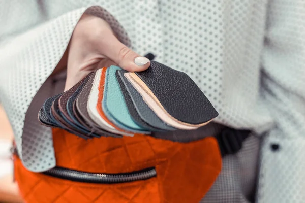 Σχεδιαστής μόδας κρατώντας μικρά κομμάτια από πολύχρωμο δέρμα — Φωτογραφία Αρχείου