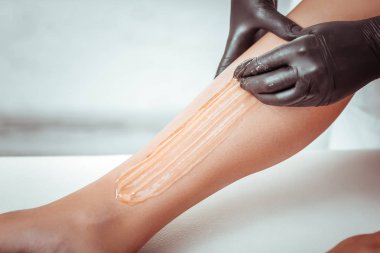 İstenmeyen tüyleri gidermek için yeni şekerleme tekniği kullanan salon işçisi