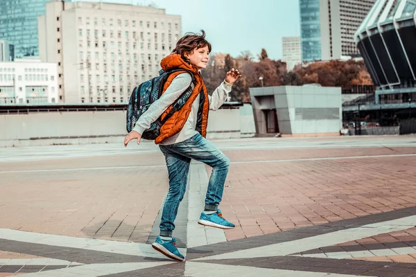 Criança alegre andando na praça com prazer — Fotografia de Stock