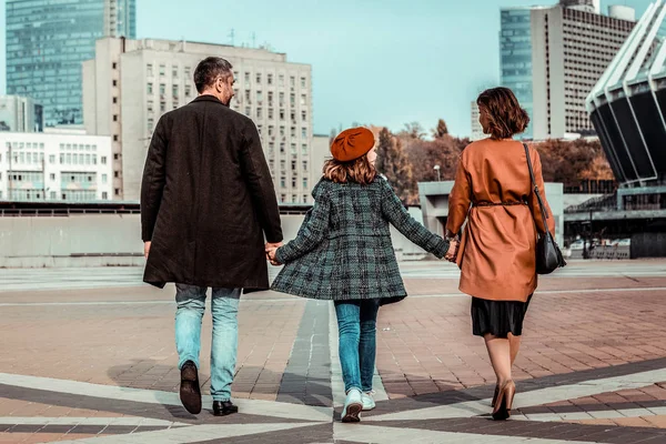 Glad tonåring går hand i hand med föräldrar — Stockfoto