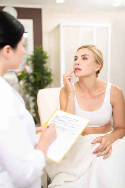 Woman showing her problems to a cosmetologist. — Stock Photo, Image