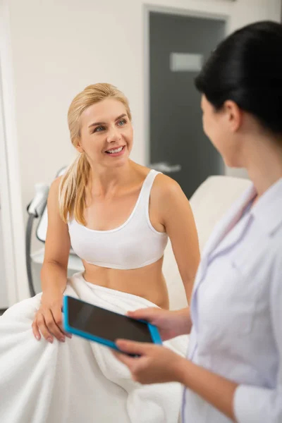 Mujer hablando con su cosmetólogo antes de los procedimientos . —  Fotos de Stock