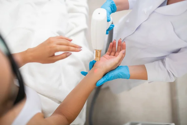 Cosmetologist fazendo polimento a laser para seu cliente . — Fotografia de Stock