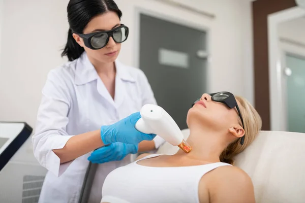 Mujer recibiendo su tratamiento láser de la piel del cuello . —  Fotos de Stock