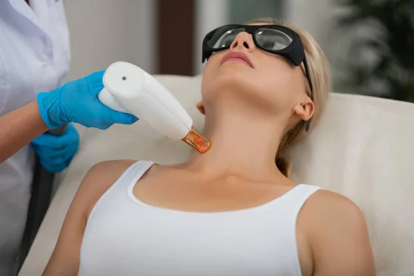 Donna bionda ottenere il suo trattamento laser della pelle del collo . — Foto Stock