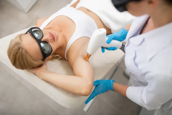 Femme obtenant l'épilation au laser dans un salon de beauté . — Photo