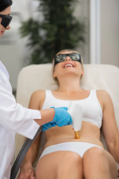 Mujer sonriendo durante su procedimiento a cosmetólogos . — Foto de Stock
