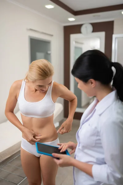 Mujer hablando con el médico de belleza sobre la pérdida de exceso de peso . — Foto de Stock