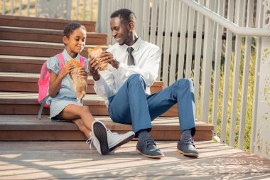 Güzel koyu tenli çocuk çörek parçası ısırmak