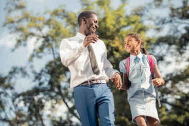 Neşeli baba ve kızı derslerinden sonra el elle yürüyüş