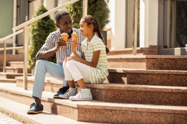 Yürüme sırasında dondurma yiyen rahat genç adam