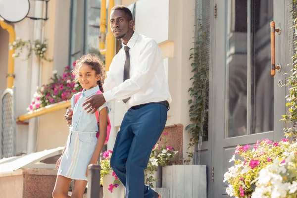 Ciddi koyu tenli adam sokak çapraz onun çocuğa yardım