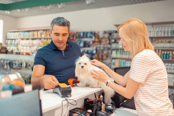 Kart tarafından kız için beyaz köpek için ödeme gri saçlı adam — Stok fotoğraf