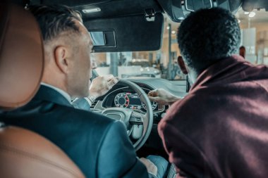 Test sürücüsü sırasında müvekkiline yardım eden araba satıcısı.