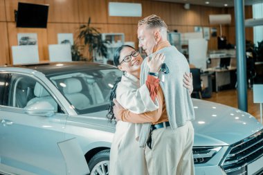 Kadın bir araba showroom onu cömert kocası sarılma.