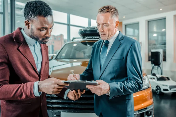 Empresario firmando un contrato comprando un coche . — Foto de Stock