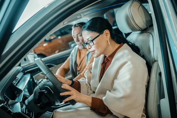 Femme explorant la voiture dans le showroom . — Photo