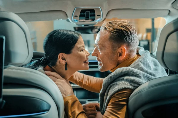 Marido e mulher sorrindo antes de beijar no carro . — Fotografia de Stock