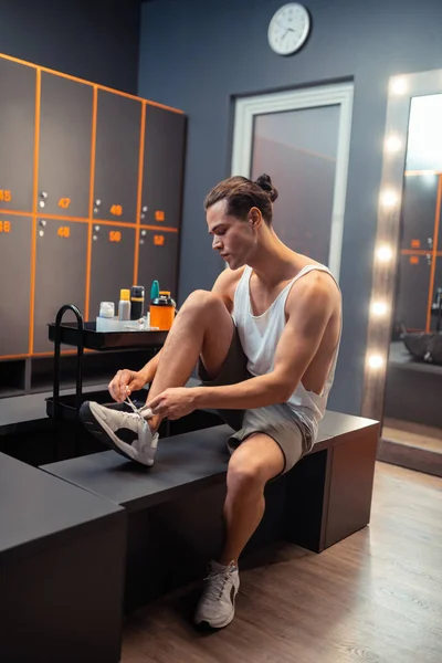 Agradável homem bonito colocando em seus sapatos — Fotografia de Stock