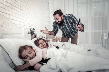 Mutlu ve gülümseyen baba kızlarına alarmı gösteriyor