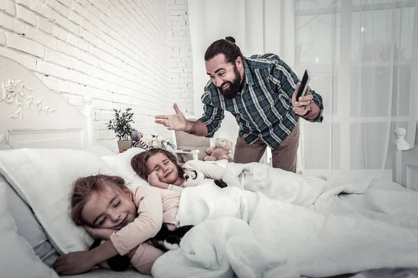 Felice e sorridente papà mostrando alle sue figlie l'allarme — Foto Stock