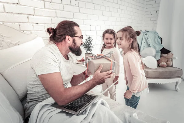 Duas meninas pequenas surpreendendo seu pai com presente de aniversário — Fotografia de Stock