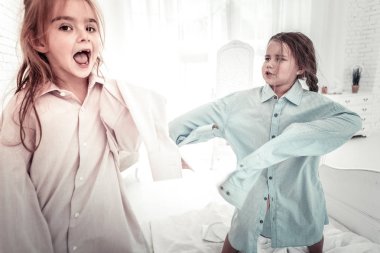 Mutlu gülümseyen çocuklar fahers gömlek yatakta atlama